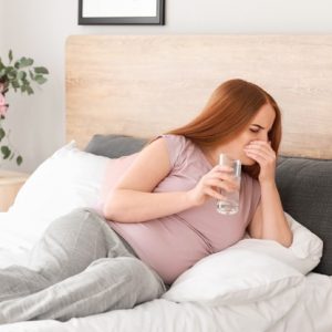 Pregnant woman suffering from morning sickness and early symptoms of pregnancy
