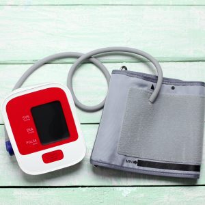 A medical device to monitor blood pressure for hypertension patient and medical cuff on a pistage wooden background