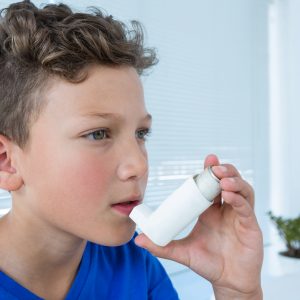 boy experience asthma attacks using asthma inhaler a clinic