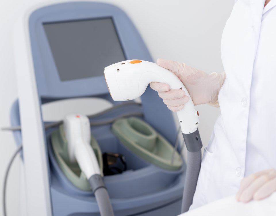 cropped shot of dermatologist with laser hair removal apparatus preparing for the session in a clinic