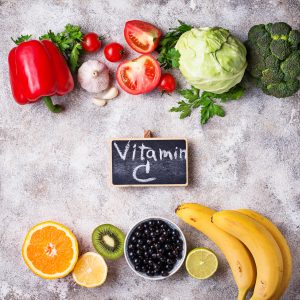 Vitamin C-written on a chalkboard next to vitamin C-containing foods