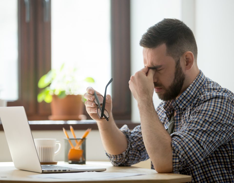 stressed man suffering massaging his nose bridge and suffering from headache