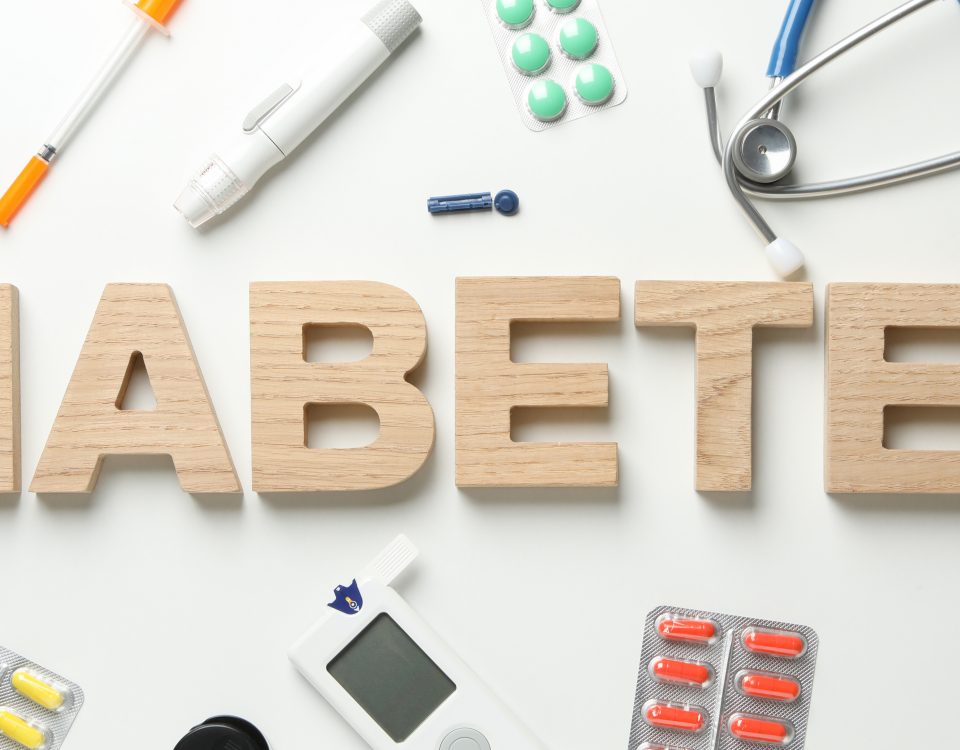 Word Diabetes made of wooden letters on white background next to Diabetes accessories